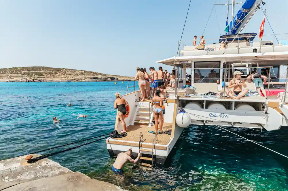 The boat alongside a rock shelf with passengers on the gangway