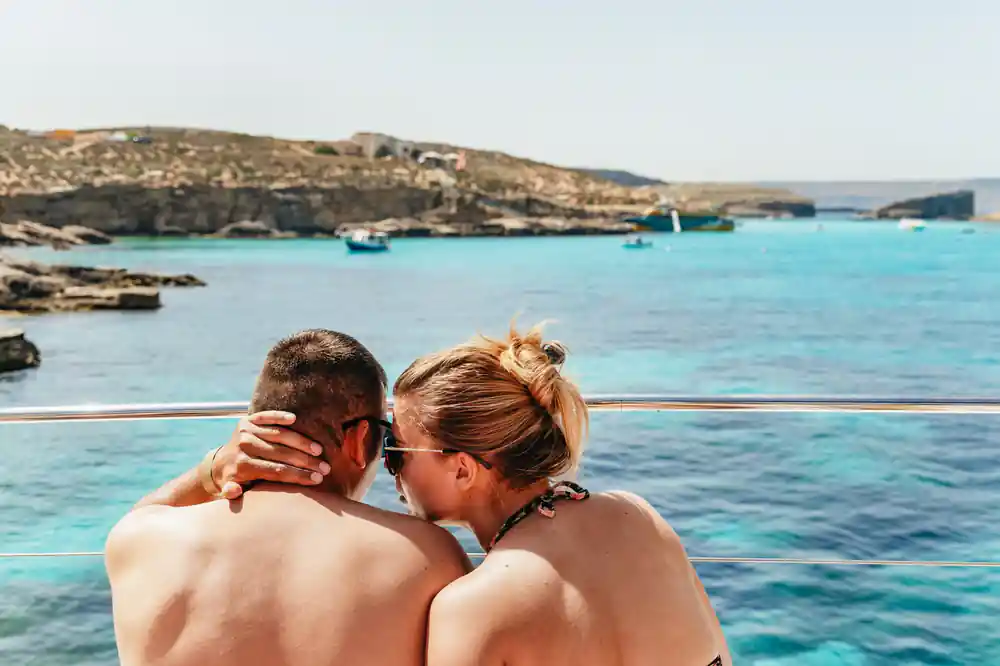A couple at the rail looking across to Comino