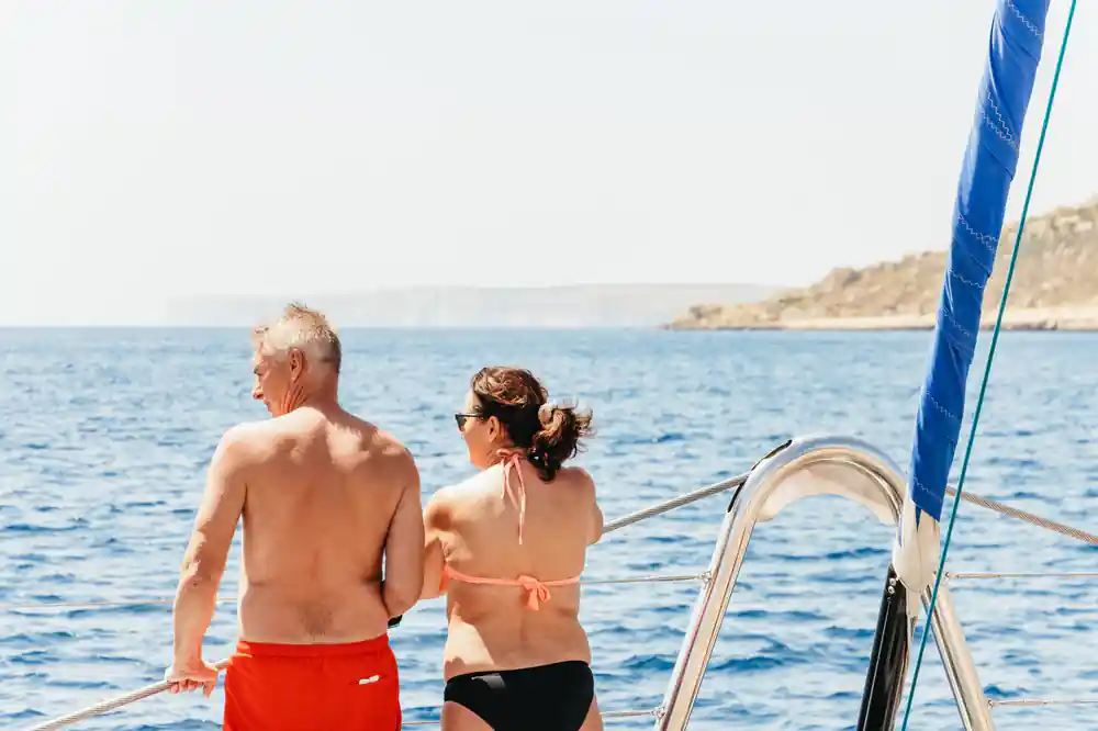 A couple standing at the stern rail looking out to an island