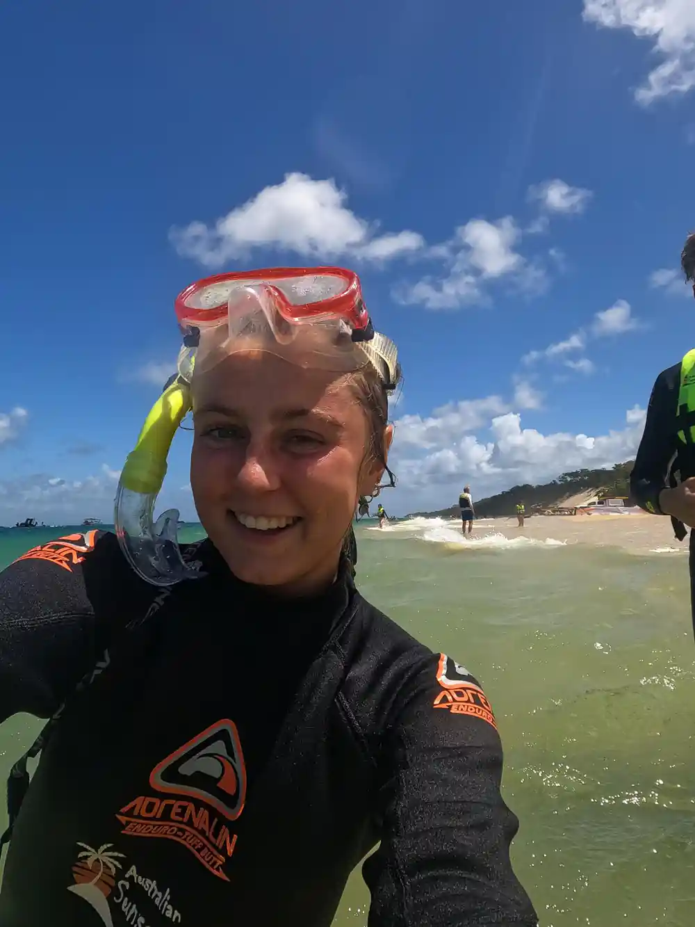 A crew member in a wetsuit with a snorkelling mask pushed up