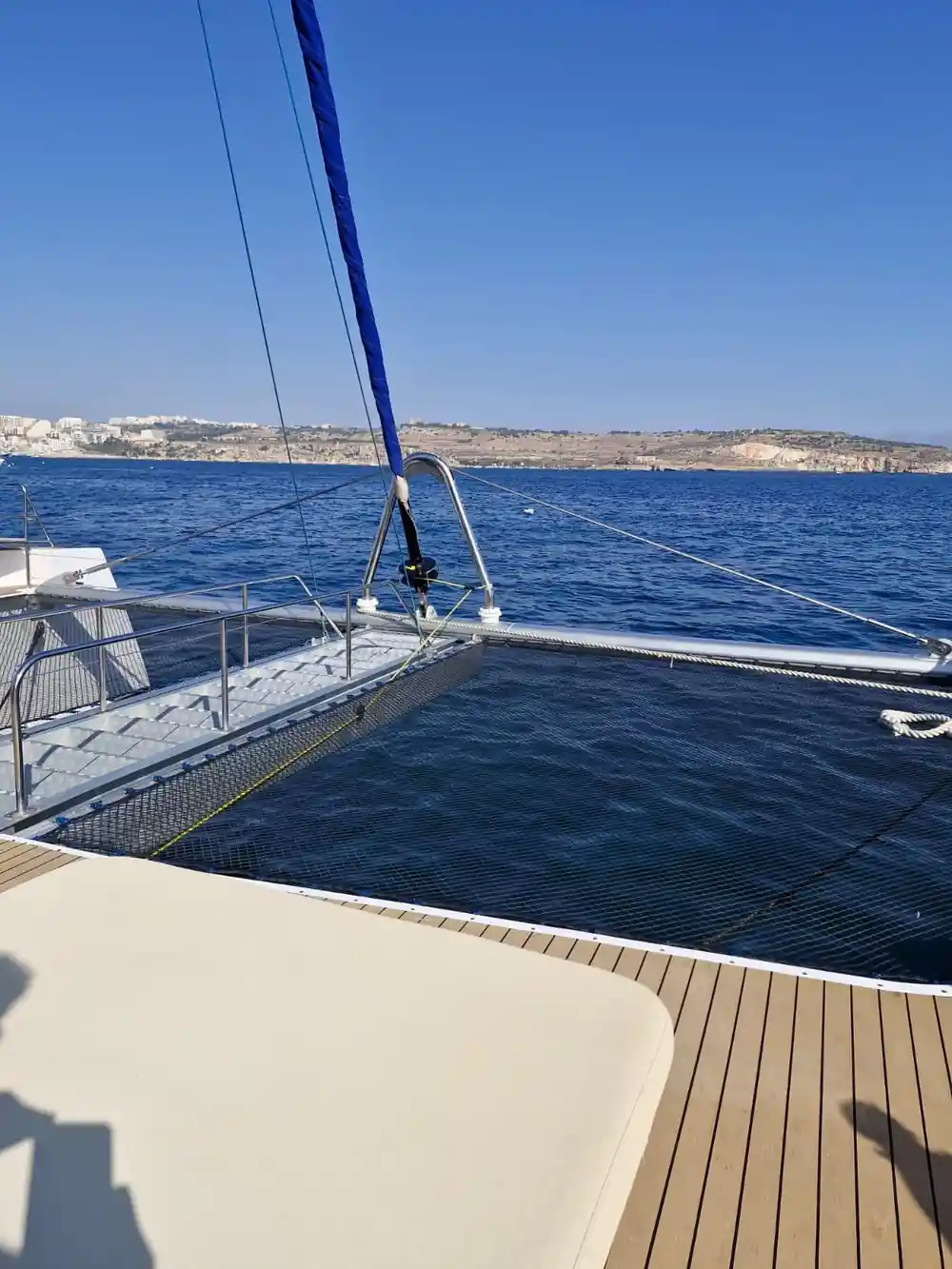 The empty foredeck and netting of the catamaran under way
