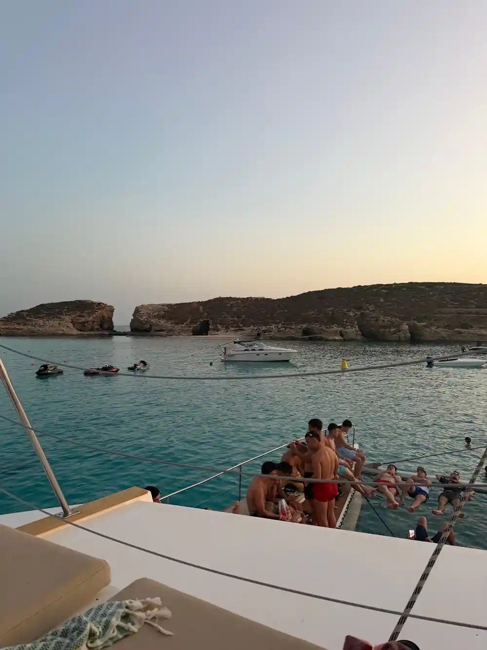 Passengers along the bow rail as the boat approaches a rock stack