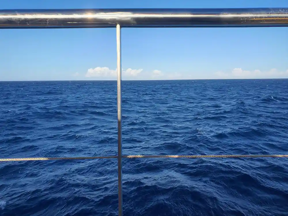 The rail and open sea on a bright day under way
