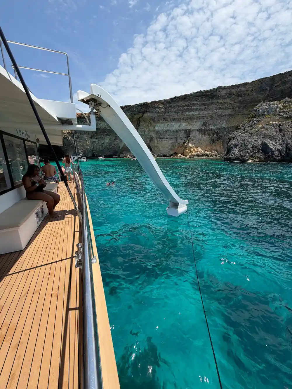 A slide running from the boat's deck down into clear green water