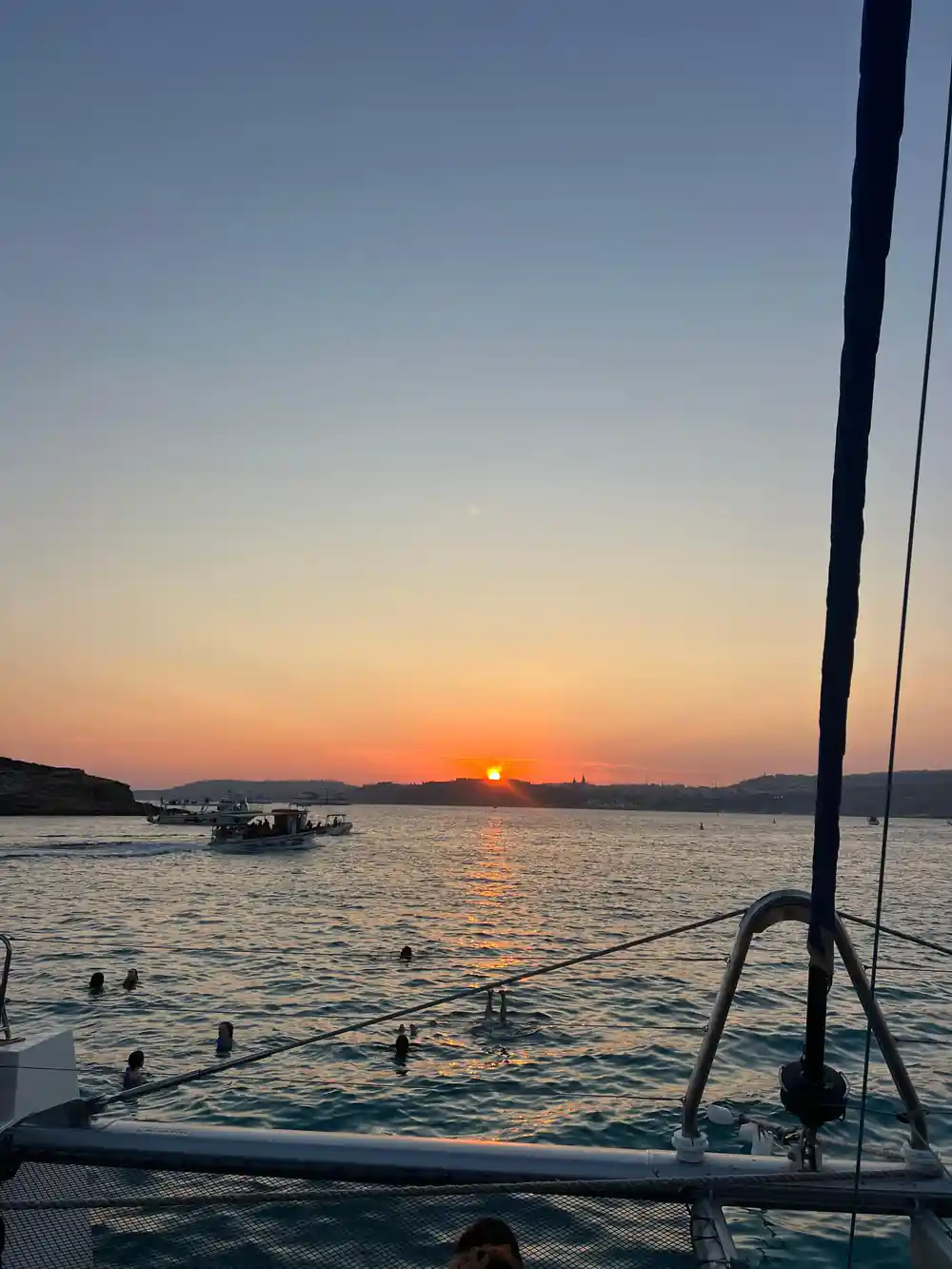 The sun going down over the sea, seen past the boat's rigging