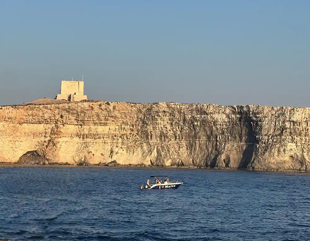 A watchtower on the cliff edge above the sea in late light